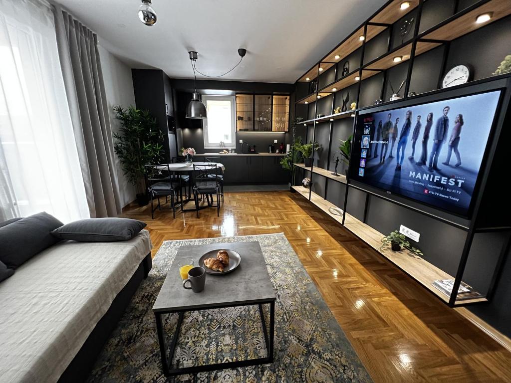 sala de estar con sofá y TV de pantalla plana en Apartment 4 two / 1 + EV Charger + Private parking, en Zagreb