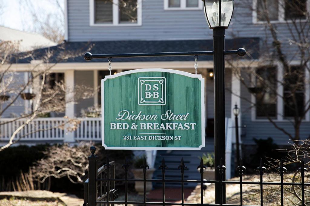 Dickson Street Bed & Breakfast في فايتيفيل: وجود علامة خضراء على السياج أمام المنزل