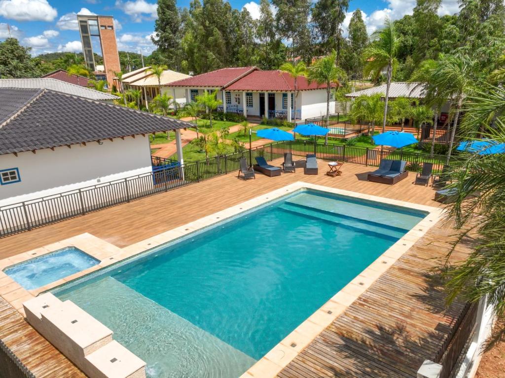 an overhead view of a swimming pool with blue umbrellas at Pousada Ouro Preto de Bonito in Bonito