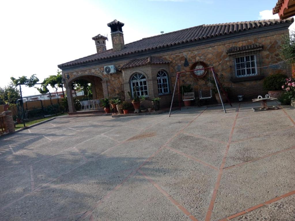kamienny budynek z placem zabaw przed nim w obiekcie Chalet Villa Terry w mieście Chiclana de la Frontera