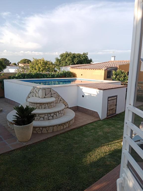 podwórko z basenem i patio z krzesłami w obiekcie Chalet Villa Terry w mieście Chiclana de la Frontera