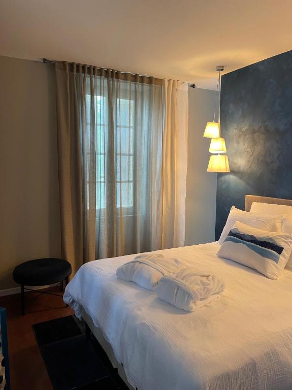 a bedroom with a white bed with a window at Le Clos Des Buis Gîte de Charme AZUL in Cazals