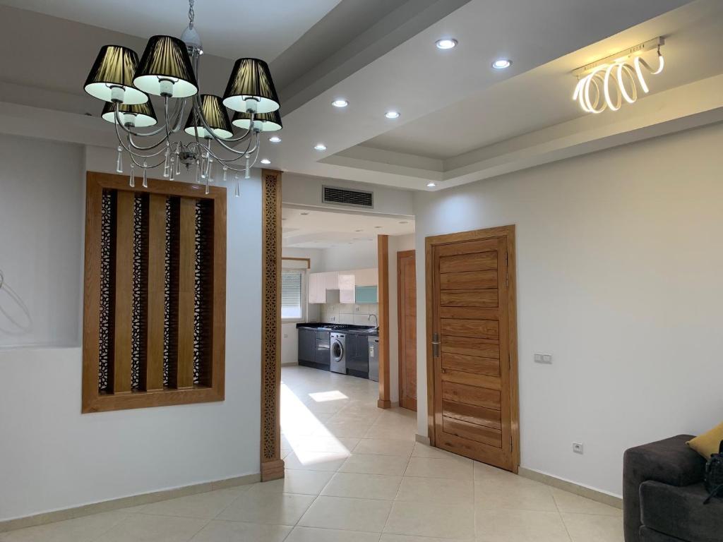 a living room with a chandelier and a hallway at La Remaz 35 in El Jadida