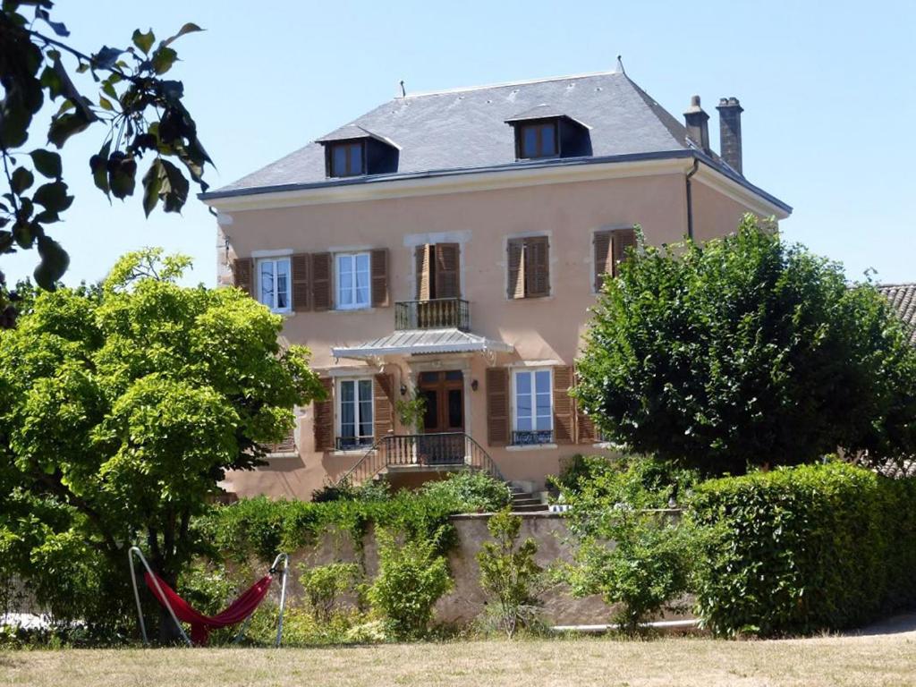 a large pink house with a red hammock in front of it at Le Clos des Tanneurs in Taponas