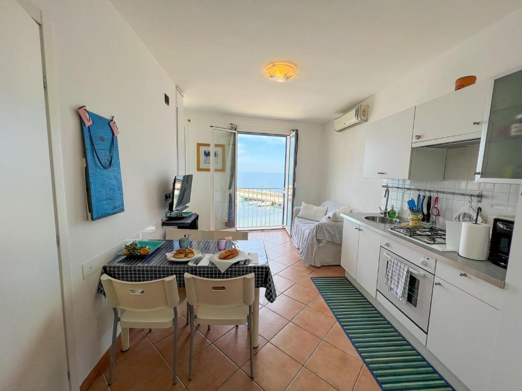 a kitchen with a table and chairs in a room at Albamare apartment in Marettimo