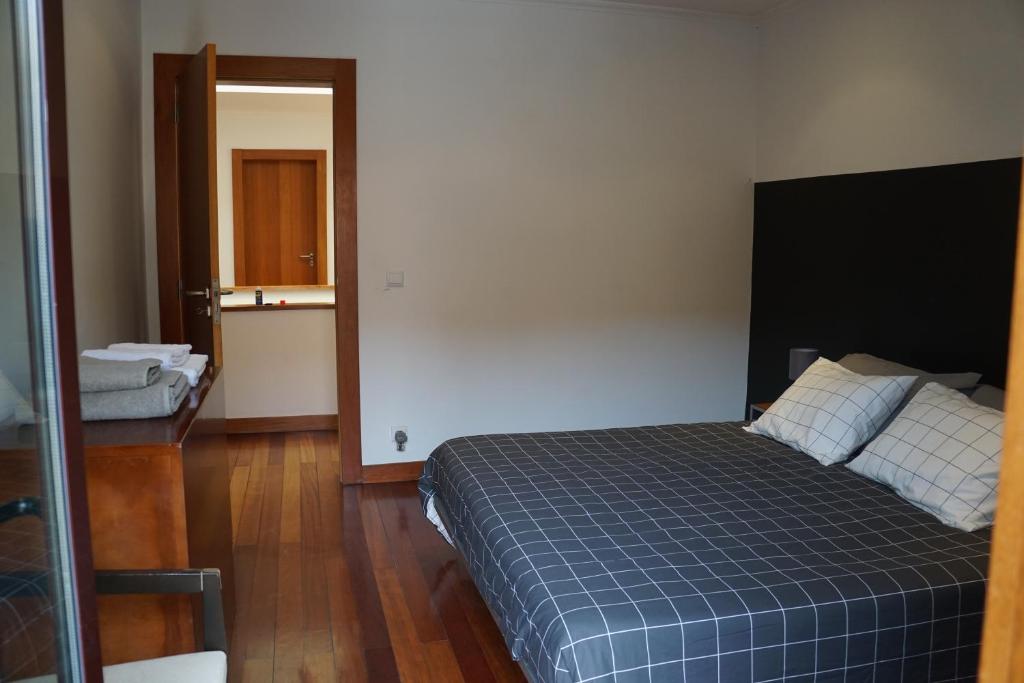 1 dormitorio con 1 cama con manta azul a cuadros en Moradia, 4 quartos, a 200 metros da praia, en Perafita