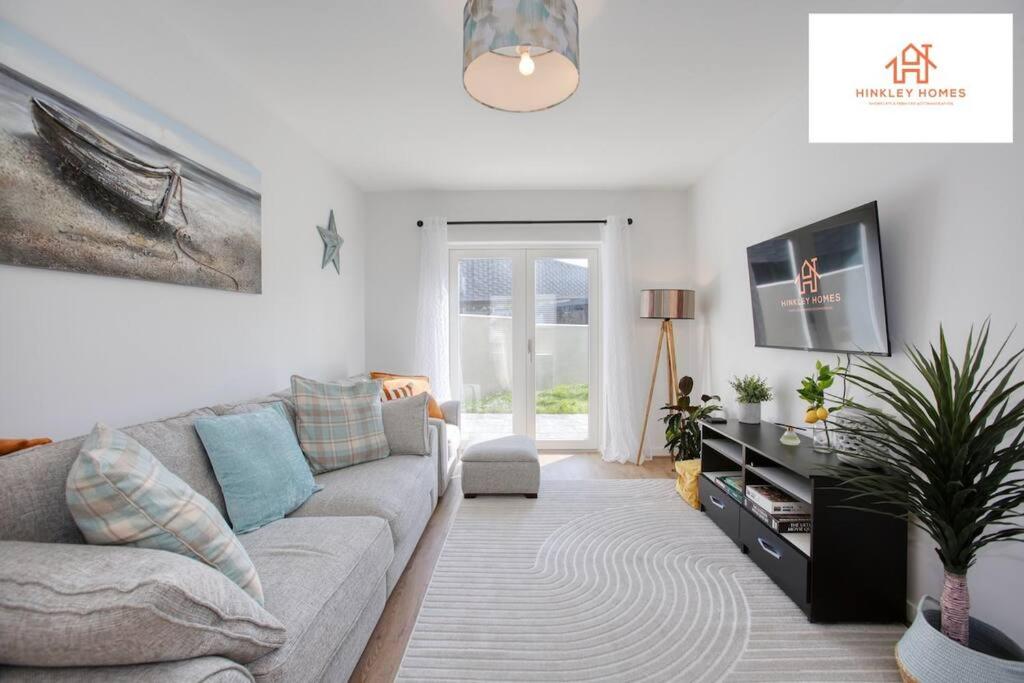 a living room with a couch and a tv at Harvey's Yard Luxury Home-St Ives-Beach-Parking 5* in Hayle