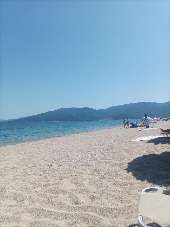 a beach with people and the ocean in the background at Exohi apartments in Nea Vrasna
