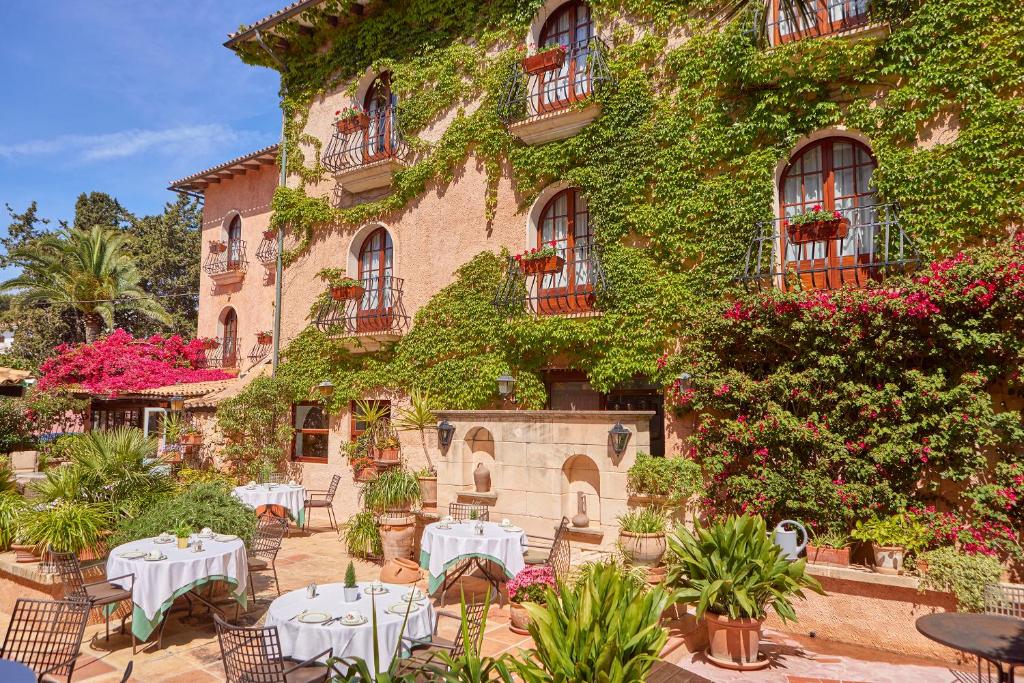 budynek ze stołami i krzesłami przed nim w obiekcie Petit Hotel Ses Rotges - Only Adults w Cala Ratjada