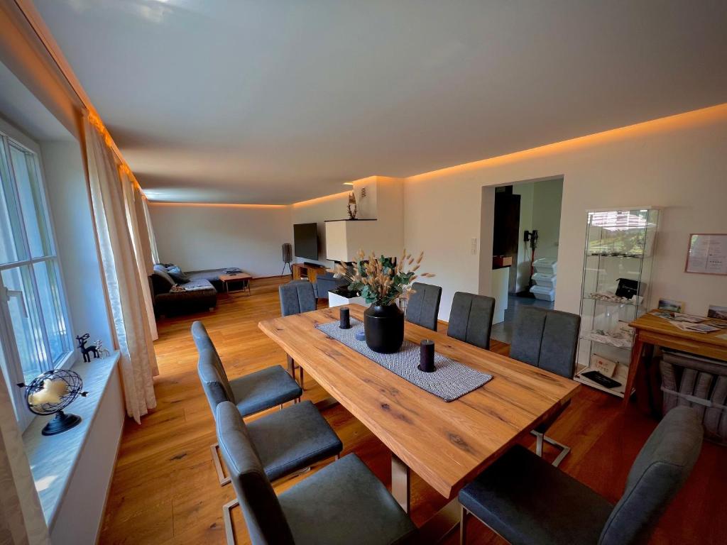 een woonkamer met een houten tafel en stoelen bij Apartment Ferienwohnung DAS UNTERACH am Attersee in Unterach am Attersee
