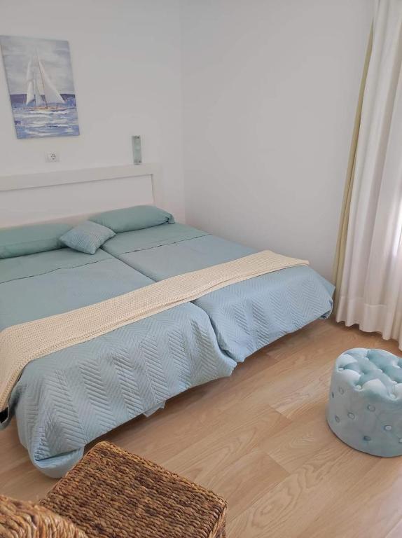 sypialnia z łóżkiem i niebieską otomaną w obiekcie Canaima 306 w mieście Puerto Rico de Gran Canaria