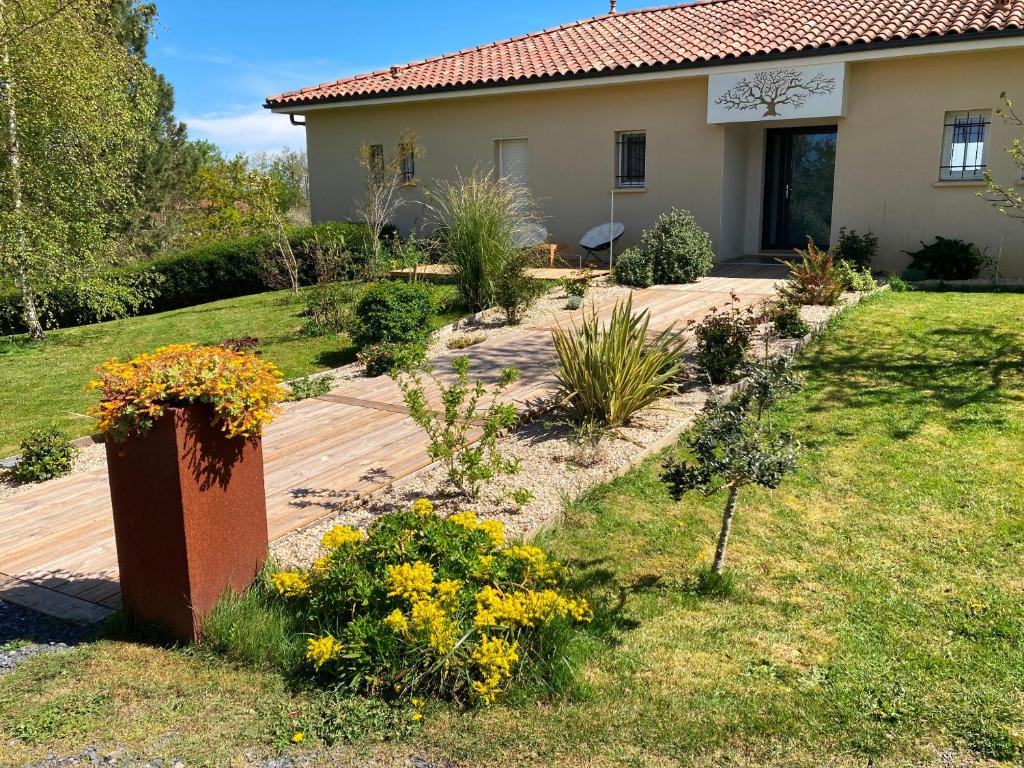 un jardín con flores frente a una casa en LE CLOS DE BAJARDAN, en Couloumé-Mondébat