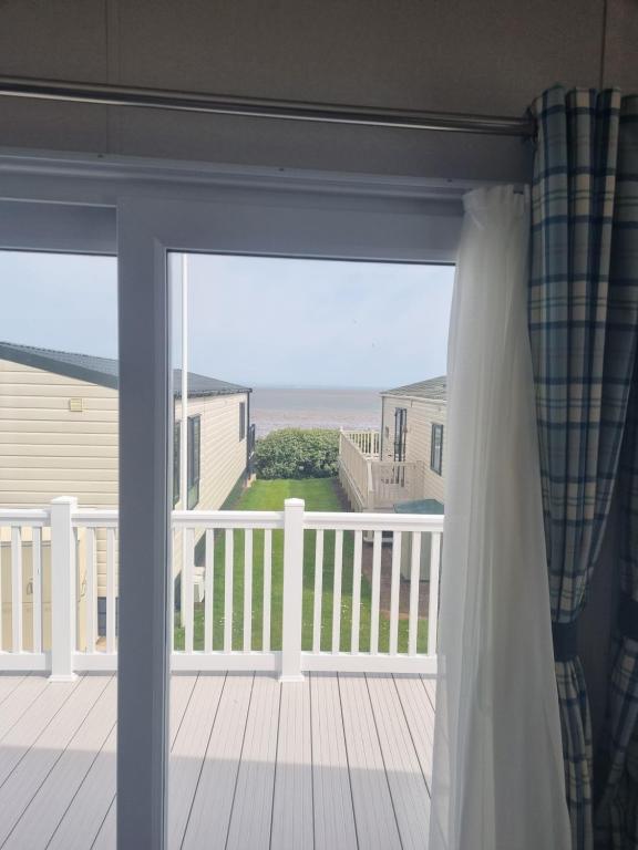 ein Fenster mit Meerblick von einer Veranda in der Unterkunft Seaside Jollys in Blue Anchor