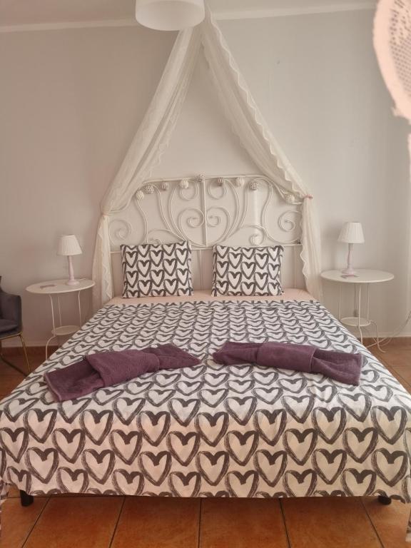 1 dormitorio con 1 cama blanca grande con almohadas moradas en Sol y Sombra Apartamento con entrada independiente, en Isla del Moral