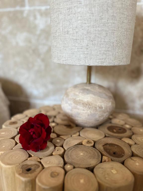 Romance en Provence في مارينيان: وجود وردة حمراء على طاولة بجانب مصباح