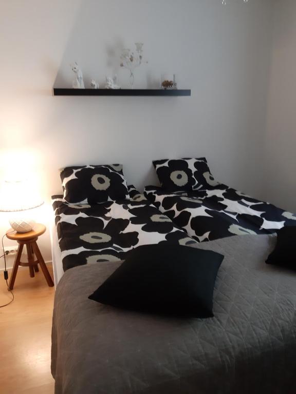 a bed with black and white pillows on it at Peltorinne 14 in Savonlinna