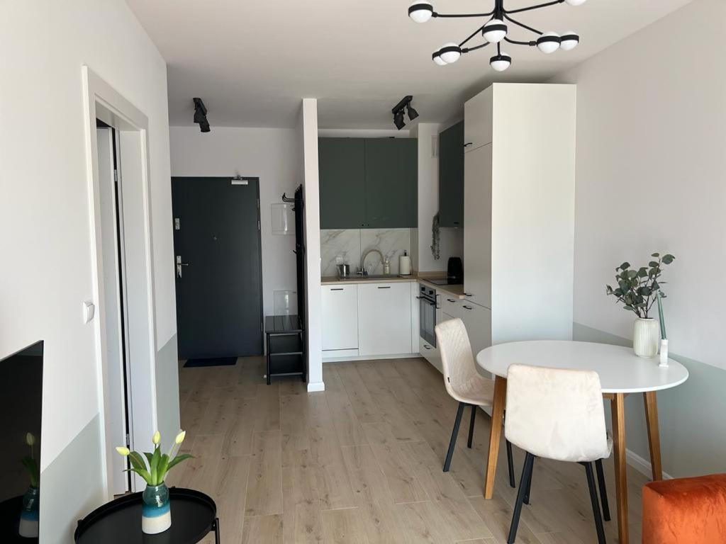 a kitchen and dining room with a table and chairs at Apartamenty Akademicka przy Onkologii 1 in Bydgoszcz