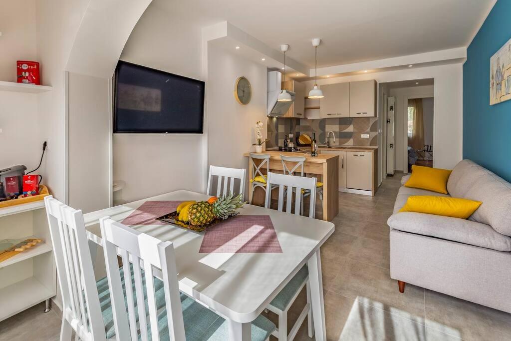 a kitchen and living room with a white table and chairs at New two bedroom apartment Maloni in Pula