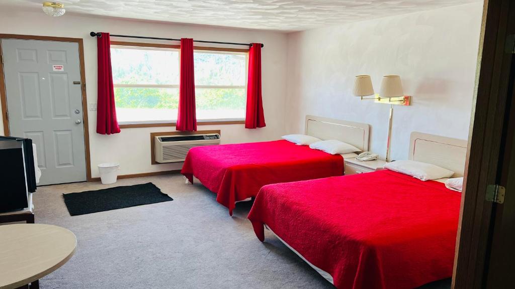 two beds in a room with red sheets at SANDS MOTEL in Boscobel