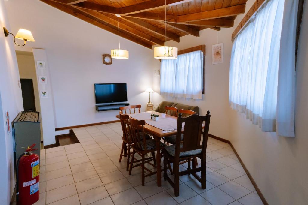 comedor con mesa, sillas y TV en Casa Roca en Ushuaia