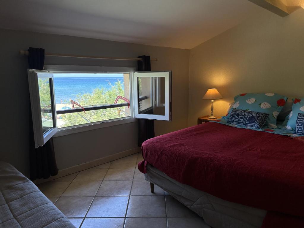 Farinole的住宿－vue mer Studio 2/3 pers 1 bed + 1 cot，一间卧室设有一张床和一个享有海景的窗户。