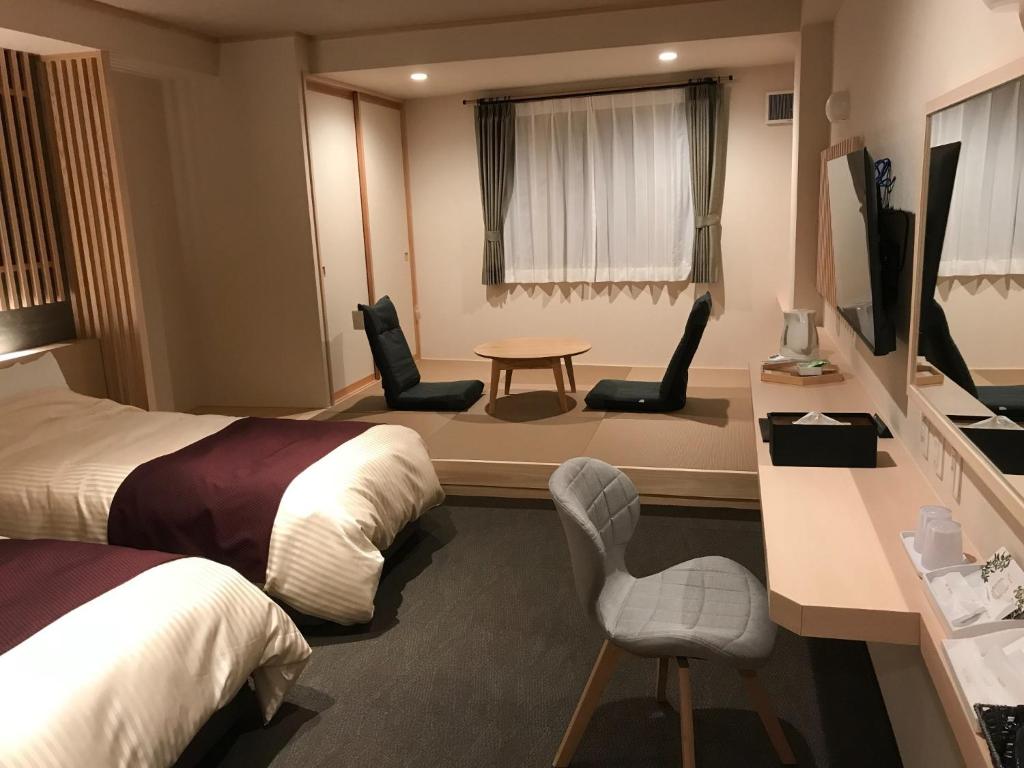 會津若松的住宿－Aizu Tsuruya Hotel - Vacation STAY 57204v，酒店客房带两张床和一张桌子以及椅子。