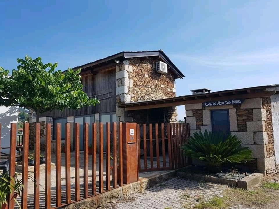 uma casa com uma cerca de madeira em frente em Casa do Alto das Fragas em Canedo de Basto