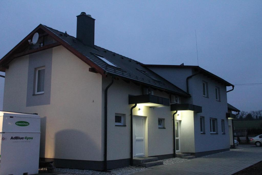 Una casa blanca con luces en el costado. en Pótkerék Motel en Győr