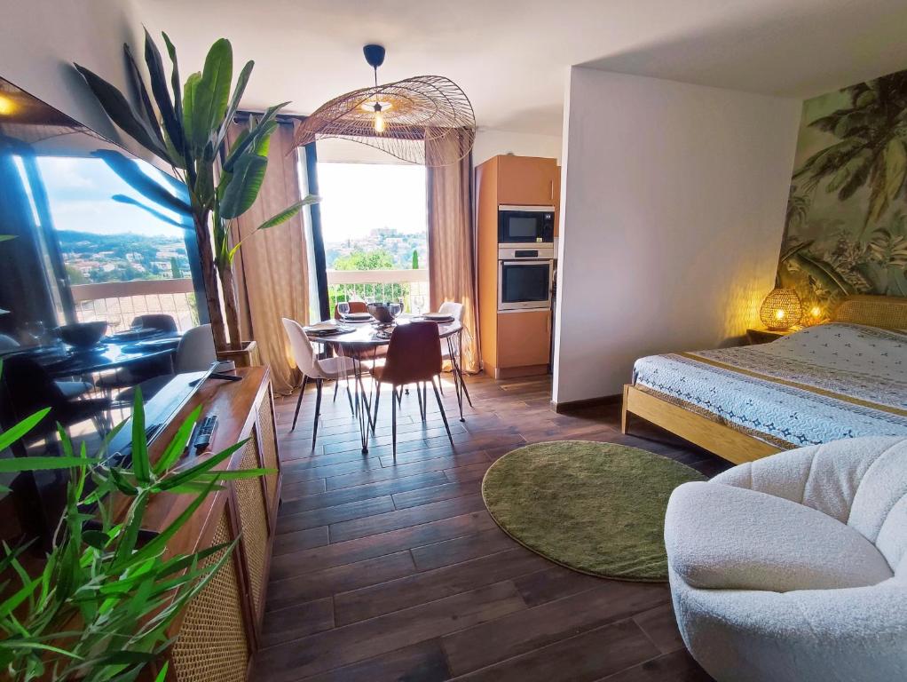 Habitación de hotel con cama y comedor en L'oasis du château ! "climatisé", en Gréoux-les-Bains