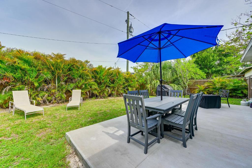 una mesa y sillas con una sombrilla azul en Dog-Friendly Home with Yard about 6 Miles to the Beach!, en Sarasota