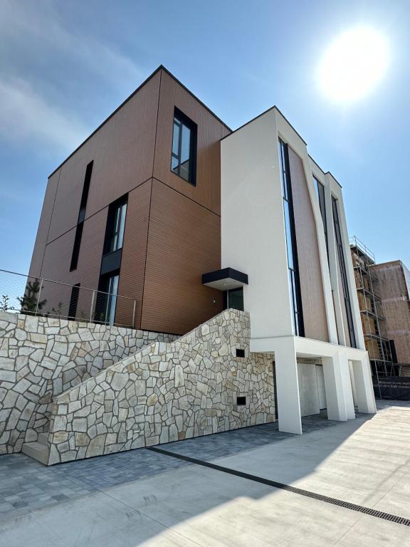 a building with a stone wall in front of it at Penati golf by Kate in Šajdíkove Humence