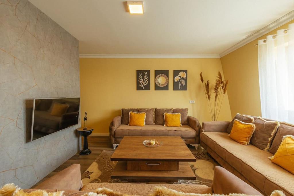 ein Wohnzimmer mit einem Sofa und einem Tisch in der Unterkunft Flamingo Apartment in Pristina
