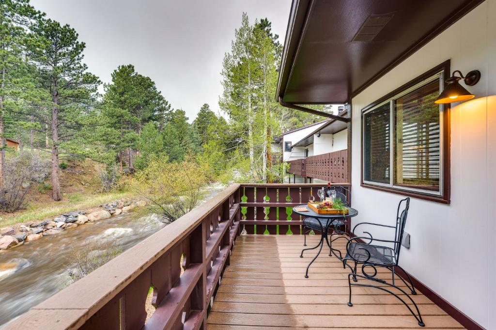 a deck with a table and chairs and a river at Estes Park Condo Rental Balcony with River Views! in Estes Park