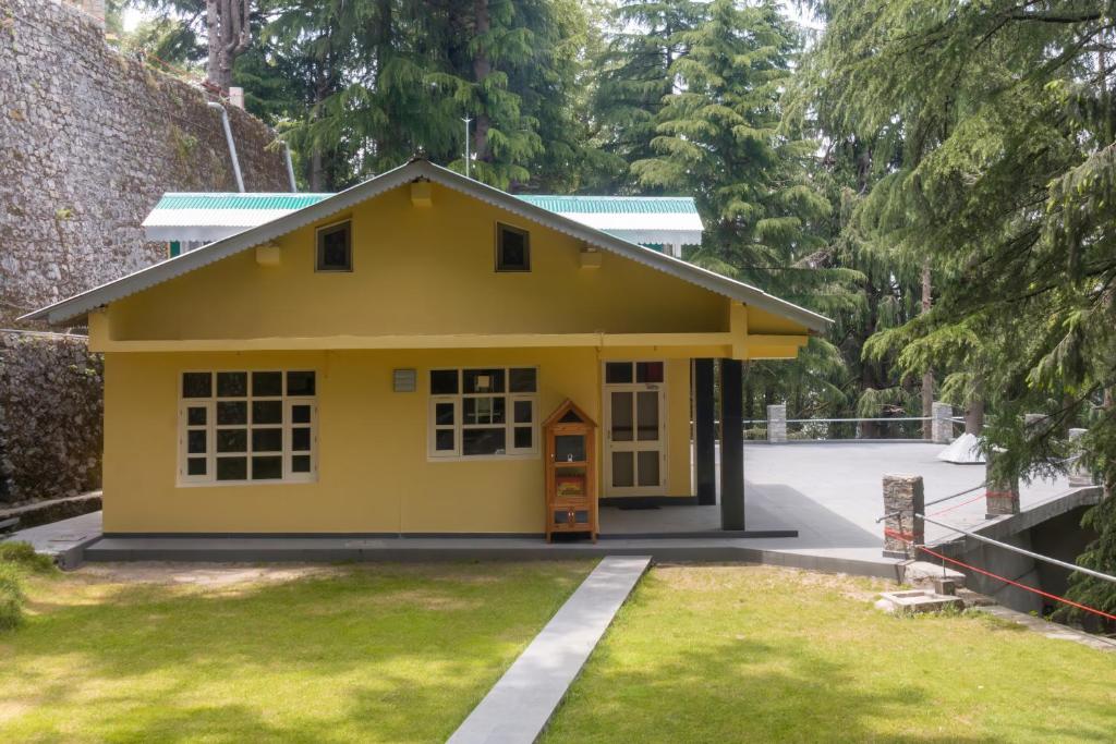a small yellow house with a yard at BluSalzz Villas - The Pine Tree, Dalhousie - Himachal Pradesh in Dalhousie