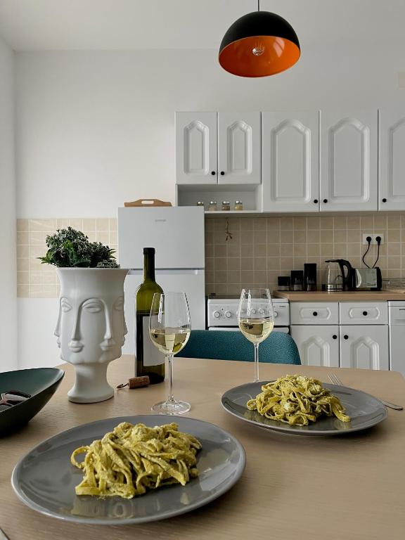 due piatti di pasta su un tavolo con bicchieri di vino di The Emerald Dream a Ohrid