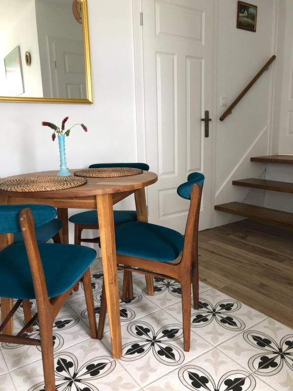 stół jadalny z niebieskimi krzesłami i lustrem w obiekcie Noclegi DobraNocka w mieście Sąpów