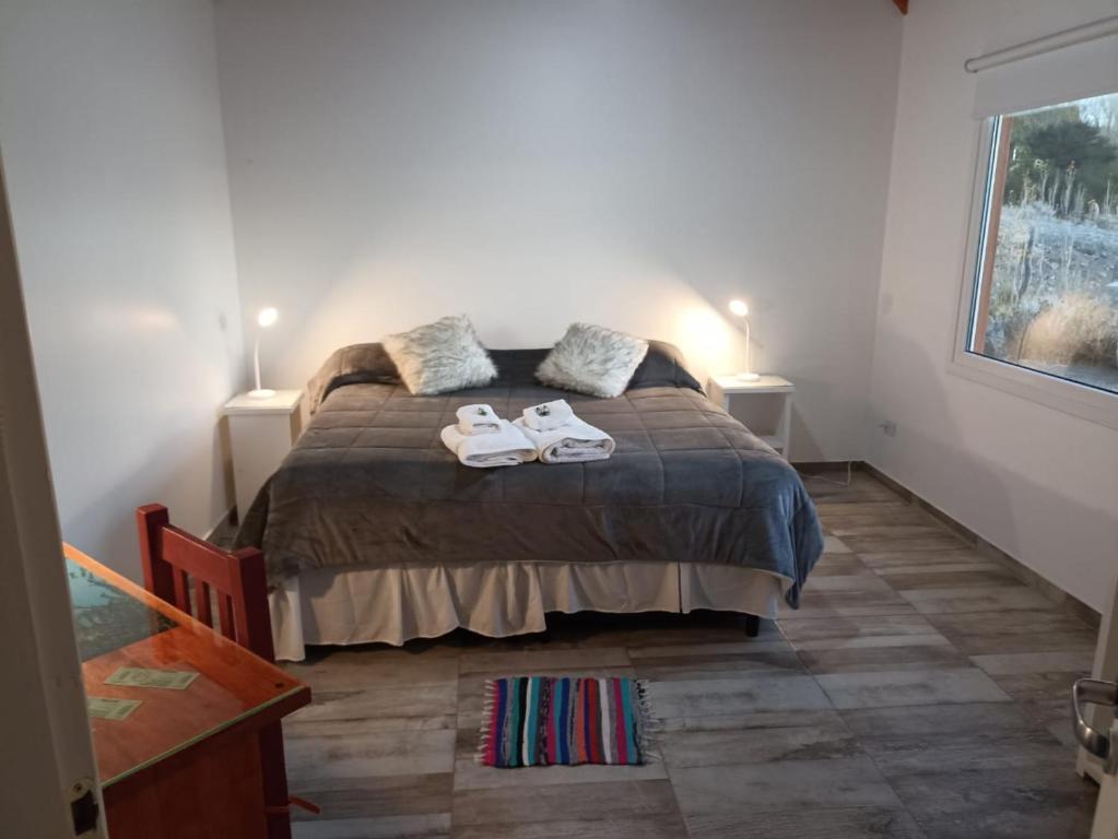 Un dormitorio con una cama con dos zapatos. en Apart Azul Calafate en El Calafate