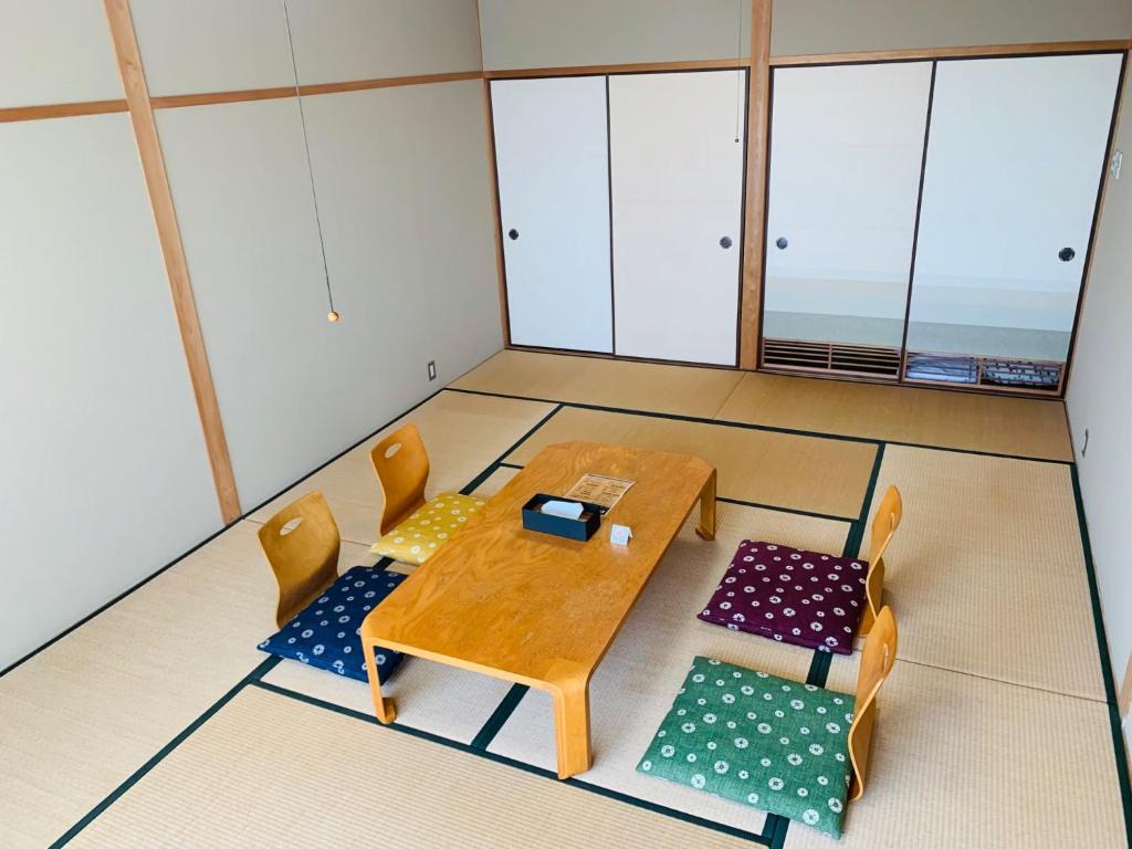 uma mesa e cadeiras num quarto com janelas em Starry Sky and Sea of Clouds Hotel Terrace Resort - Vacation STAY 51677v em Takeda