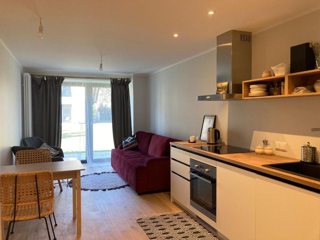 a kitchen and living room with a couch and a table at Albatross Seaside Escape in Ķesterciems