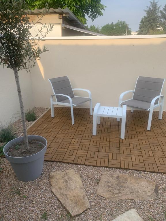 2 chaises et un banc assis sur une terrasse dans l'établissement villa bleu marine chic calme et jardin, à Andrézieux-Bouthéon