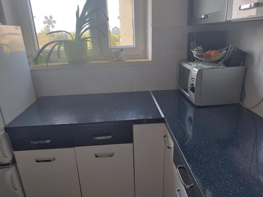 a kitchen with a black counter top and a microwave at Vip apart in Gorlice
