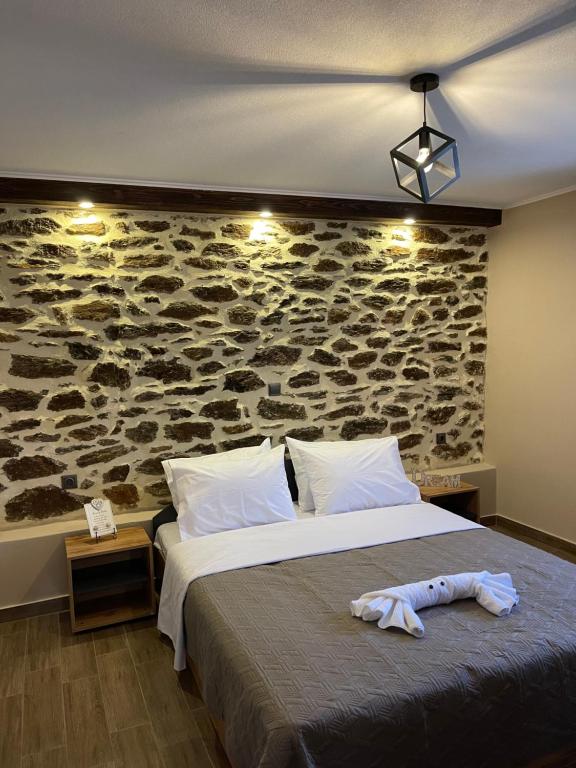 una camera da letto con un grande letto e un muro in pietra di Chalkidiki AsterGia apartments a Metangítsion