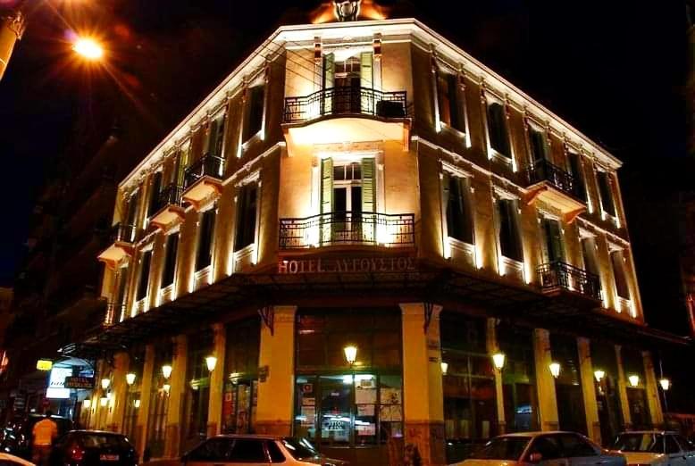 a lit up building with cars parked in front of it at Augustos in Thessaloniki