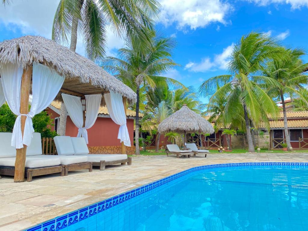 a resort with a swimming pool and palm trees at Hotel Pousada Beleza das Ondas in Cumbuco