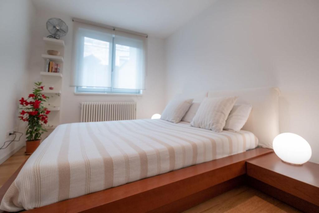 - une chambre blanche avec un grand lit et une fenêtre dans l'établissement Residence Santa Tecla, à Trieste