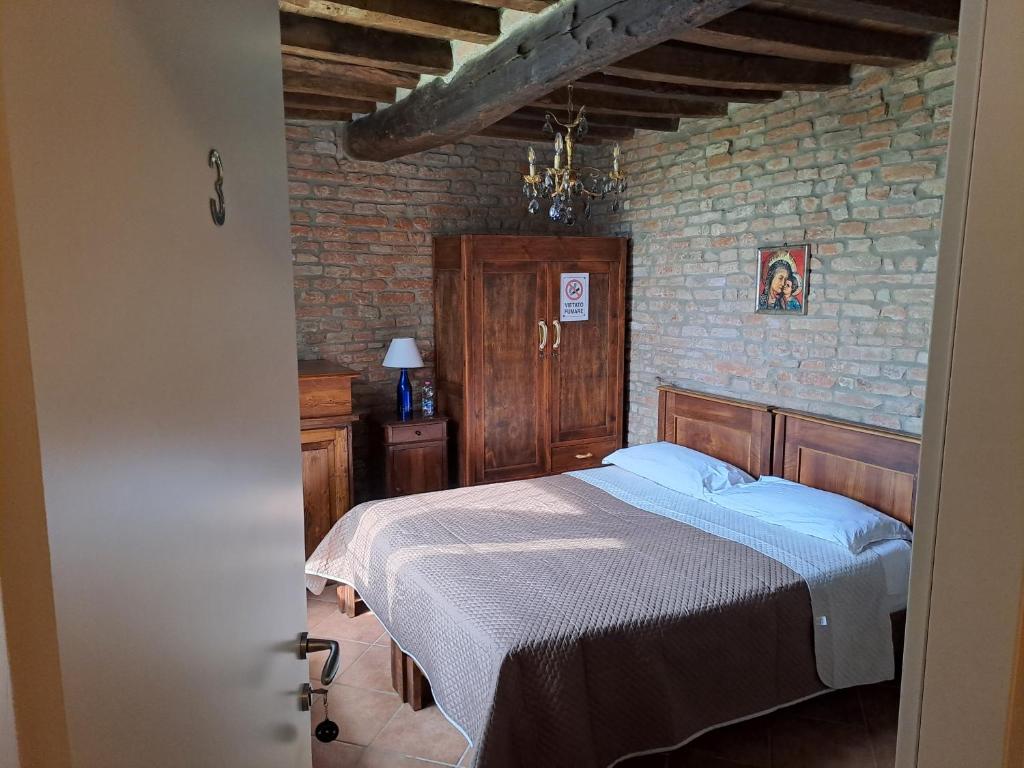 - une chambre avec un lit et un mur en briques dans l'établissement B&B All'Aeroporto, à Curtatone