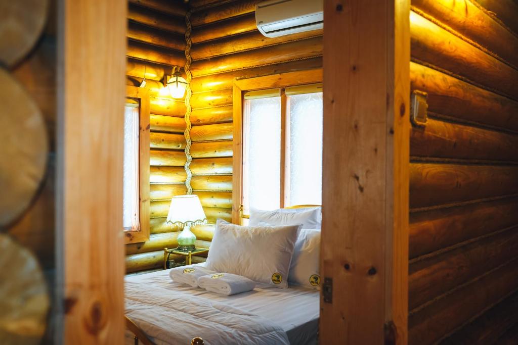 a bedroom with a bed in a log cabin at DatzVilla Pantai Air Tawar Besut Terengganu in Kampung Raja
