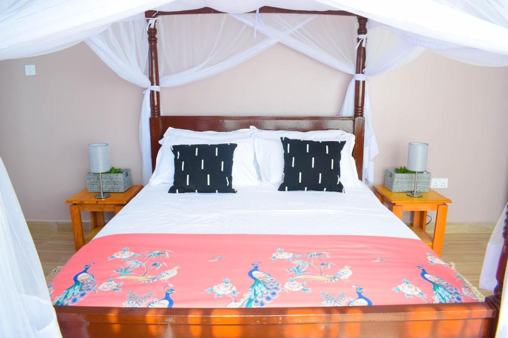 a bedroom with a bed with a bedspread with birds on it at Ilala House, Voi - 2 bed, 2 bath in Voi