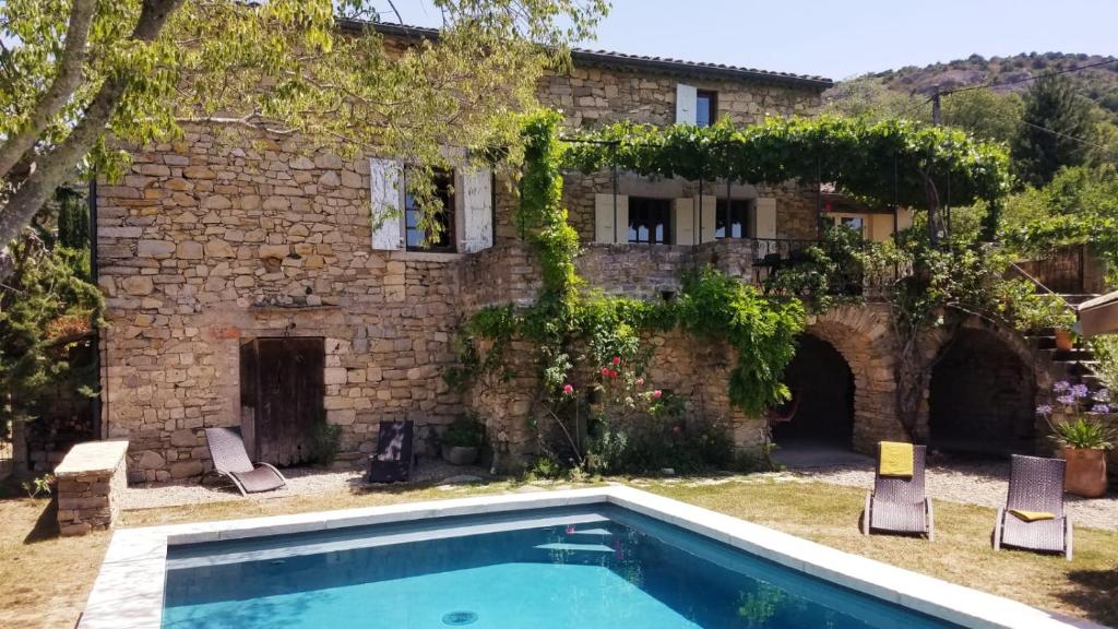 une maison avec piscine devant un immeuble dans l'établissement Maison de caractère La Calade, à Rochecolombe