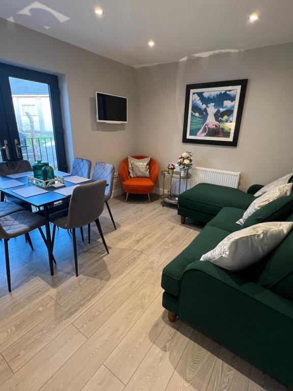 a living room with a green couch and a table at seaview 87 in Portrush